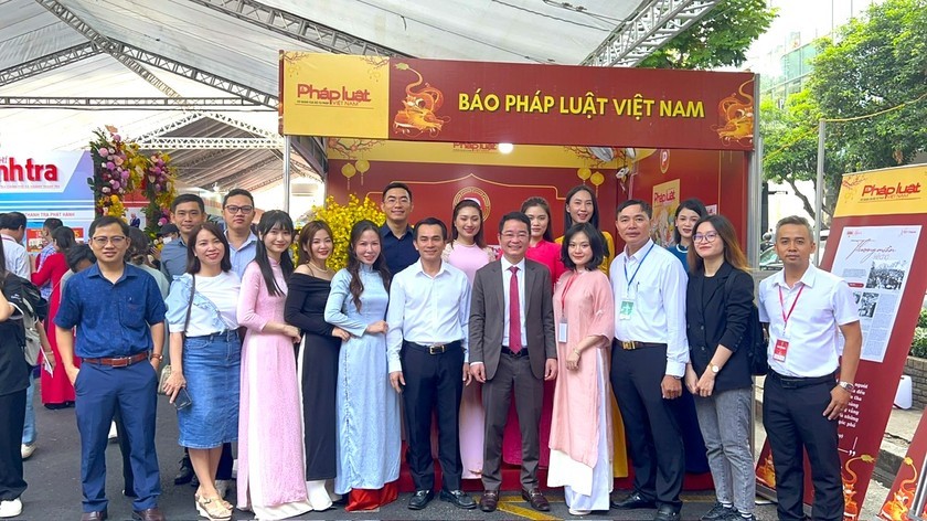 Tổng Biên tập Báo Pháp luật Việt Nam (thứ 5 từ phải sang) cùng các phóng viên của báo tại gian hàng trưng bày của Báo.