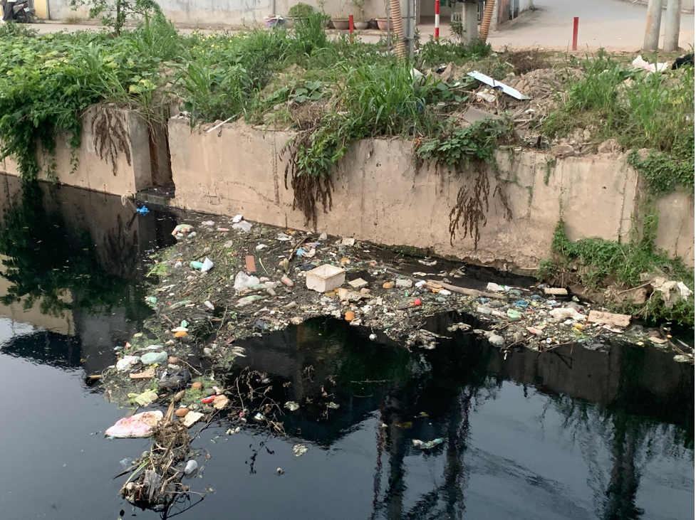 Nước sông đen ngòm kèm theo rác thải sinh hoạt và mùi hôi thối bốc lên trên đoạn sông Cầu Bây gây ảnh hưởng không nhỏ đến đời sống người dân xung quanh.