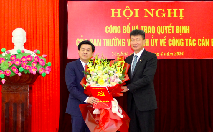 Đồng chí Trần Huy Tuấn - Phó Bí thư Tỉnh ủy, Chủ tịch UBND tỉnh Yên Bái trao Quyết định và tặng hoa chúc mừng đồng chí tân Phó Trưởng Ban Nội chính Tỉnh ủy.