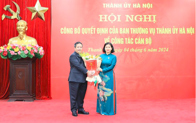 Phó Bí thư Thường trực Thành ủy Hà Nội Nguyễn Thị Tuyến trao quyết định, tặng hoa chúc mừng ông Nguyễn Tiến Cường.