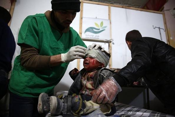 Nh&acirc;n vi&ecirc;n y tế đang băng b&oacute; cho một b&eacute; trai Syria bị thương khi lực lượng ch&iacute;nh phủ tấn c&ocirc;ng thị trấn Douma do phe nổi dậy kiểm so&aacute;t. Ảnh:&nbsp;Getty.
