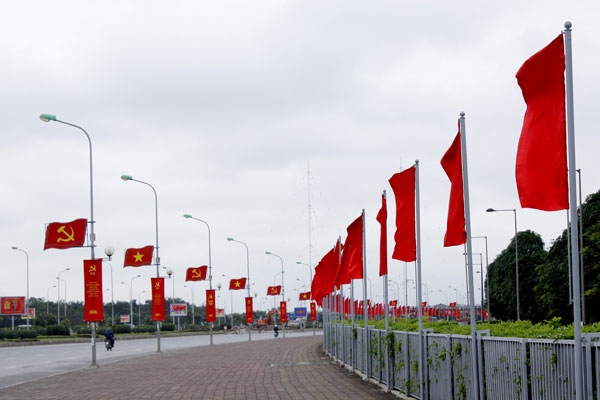 Pano, cờ đỏ tung bay trước Trung t&acirc;m Hội nghị Quốc gia.