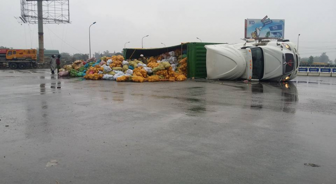 Chiếc xe container chở 30 tấn dừa bị lật giữa đường.
