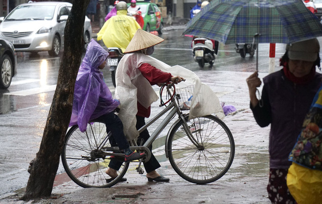Kh&ocirc;ng chỉ mưa, thời tiết cũng lạnh khiến c&aacute;c em nhỏ phải mặc &aacute;o mưa k&iacute;n m&iacute;t để đến trường.