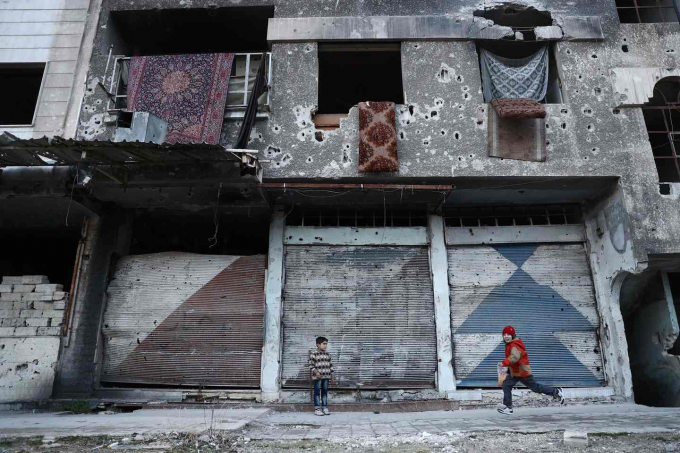 Những đứa trẻ chơi đ&ugrave;a b&ecirc;n cạnh một t&ograve;a nh&agrave; đổ n&aacute;t tại thị trấn Douma - nơi bị phiến qu&acirc;n chiếm đ&oacute;ng tại ngoại thủ đ&ocirc; Damascus. (Ảnh: AFP / Getty Images)