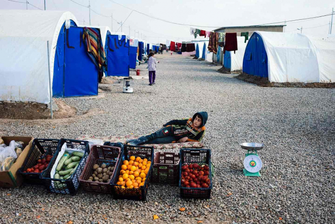 Một đứa trẻ b&aacute;n rau nằm nghỉ tại trại tị nạn Khazer d&agrave;nh cho những người chạy trốn khỏi th&agrave;nh tr&igrave; của Nh&agrave; nước Hồi gi&aacute;o tại Mosul. (Ảnh: AFP / Getty Images)