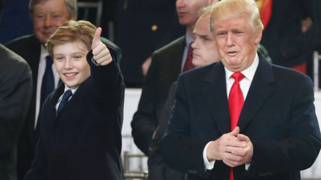 Tổng thống Mỹ Donald Trump (phải) v&agrave; cậu con &uacute;t Barron trong lễ diễu h&agrave;nh nhậm chức h&ocirc;m 20/1. (Ảnh: Fox News)