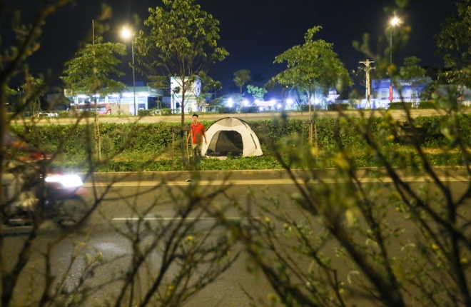 Khoảng 4 km dọc đường Phạm Văn Đồng l&agrave; những chiếc giường ngủ d&atilde; chiến, lều bạt hoặc c&aacute;i v&otilde;ng nằm vắt vẻo b&ecirc;n lề đường.