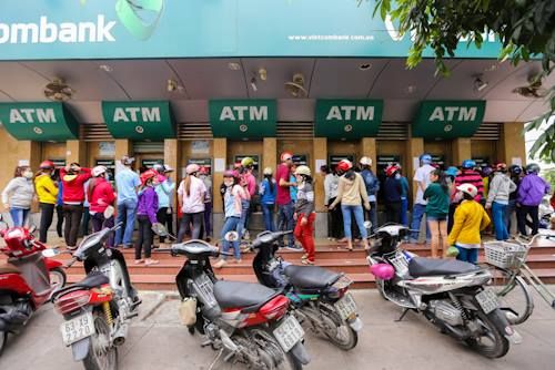 D&ograve;ng người tập trung trước trụ ATM ở khu chế xuất T&acirc;n Thuận, quận 7 chờ để r&uacute;t tiền.