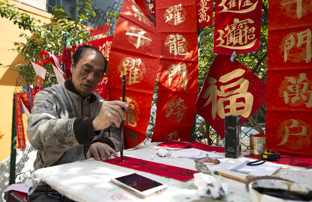 Xin c&acirc;u đối, xin chữ để treo dịp Tết cũng l&agrave; một phong tục được người d&acirc;n nhiều nơi coi trọng mỗi dịp đầu năm mới, trong đ&oacute; c&oacute; cả Hong Kong (Ảnh: Reuters)
