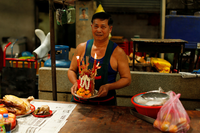 Một người đ&agrave;n &ocirc;ng d&acirc;ng lễ c&uacute;ng nh&acirc;n dịp năm mới tại một khu chợ ở Bangkok, Th&aacute;i Lan. (Ảnh: Reuters)