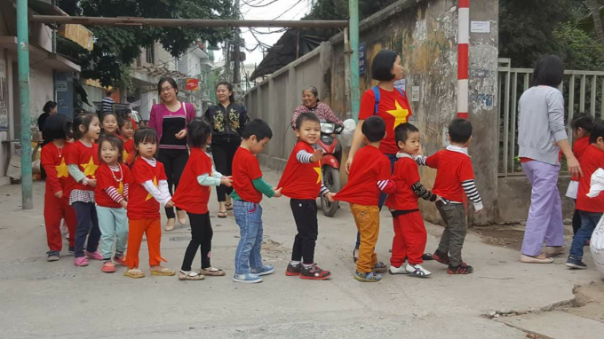 Một g&oacute;c phố tại H&agrave; Nội, phụ huynh cũng cho những đứa trẻ tập cổ vũ trước trận đấu U23 Việt Nam.