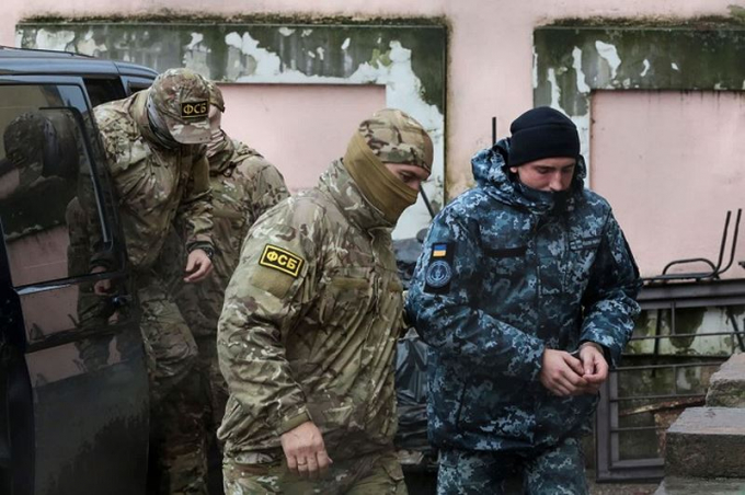 Thủy thủ Ukraina bị binh sĩ Nga dẫn giải ra t&ograve;a sau lần Nga nổ s&uacute;ng bắt t&agrave;u Ukraina.