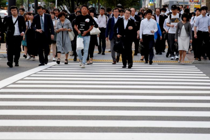 Người đi bộ đang băng qua đường ở Nhật Bản. Ảnh: Reuters