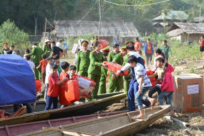 Đoàn thiện nguyện cùng các em học sinh vận chuyển quà từ thuyền lên trường THCS Hữu Khuông