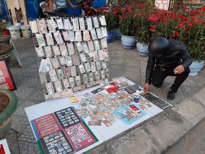Du khách thích thú trước gian hàng bán tiền cổ và những đồng tiền nước ngoài được trưng bày dọc chợ Hoa tết.