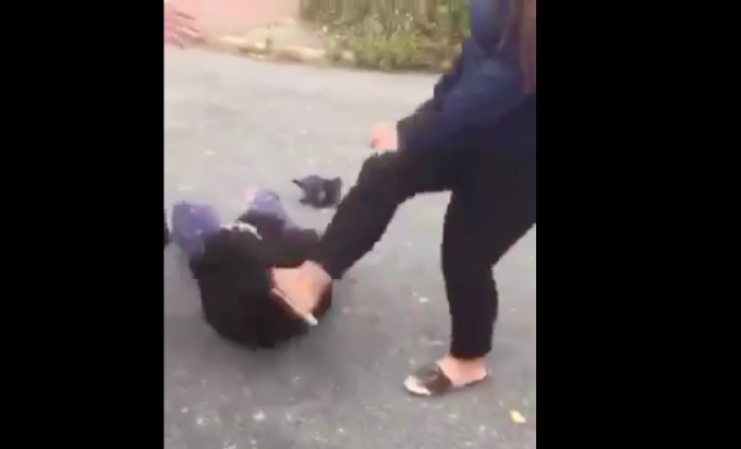 Hình ảnh một trong hai nữ sinh bị đánh đập hội đồng giữa ban ngày (ảnh cắt từ clip).