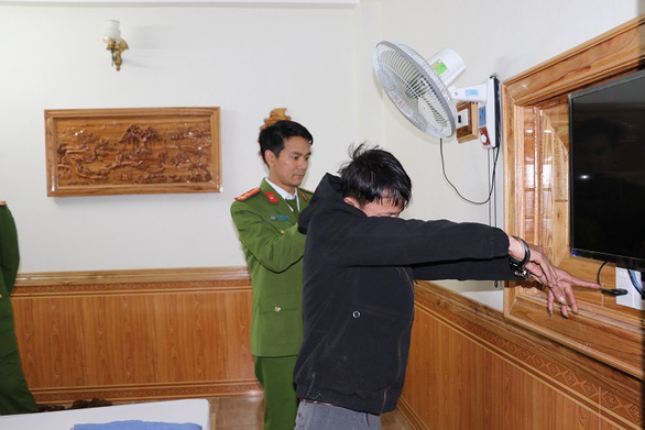 Trần Văn Ninh (áo đen) chỉ nơi giấu camera ghi lại cảnh ân ái của các cặp đôi rồi tống tiền - Ảnh: Công an cung cấp