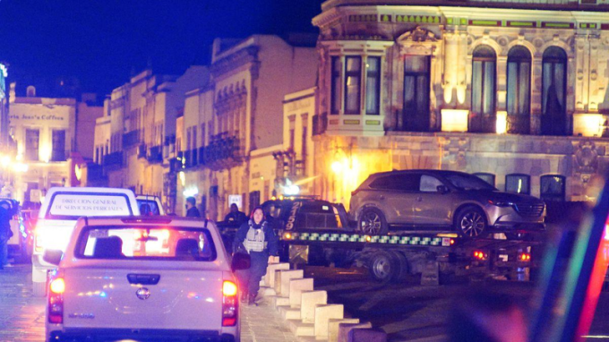 Lực lượng cảnh sát làm việc tại hiện trường khi họ di chuyển một chiếc xe có thi thể bị bỏ trước Văn phòng Thống đốc ở Zacatecas, Mexico ngày 6/1/2022. Ảnh: Reuters