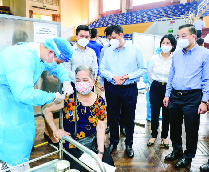 Bộ trưởng Bộ Y tế Nguyễn Thanh Long (đứng giữa) kiểm tra công tác tiêm chủng vaccine phòng COVID-19 tại Hà Nội. Ảnh: Trần Minh