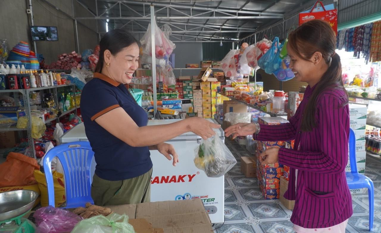 Chị Trương Thị Ly (góc trái) bán hàng cho người dân trong khu tái định cư. Chị cho biết bắt đầu quen dần với cuộc sống