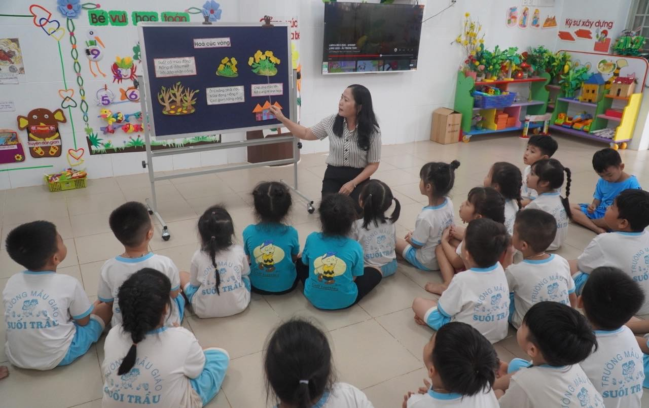 Cô Kim Anh, giáo viên Trường mầm non Suối Trầu hướng dẫn các trẻ chơi, tìm hiểu kiến thức. Nhà trường hiện có 145 trẻ đều là con em người dân trong khu tái định cư, đây là ngôi trường đầu tiên và duy nhất hiện nay đã đưa vào hoạt động, còn lại vẫn chưa hoàn thành.
