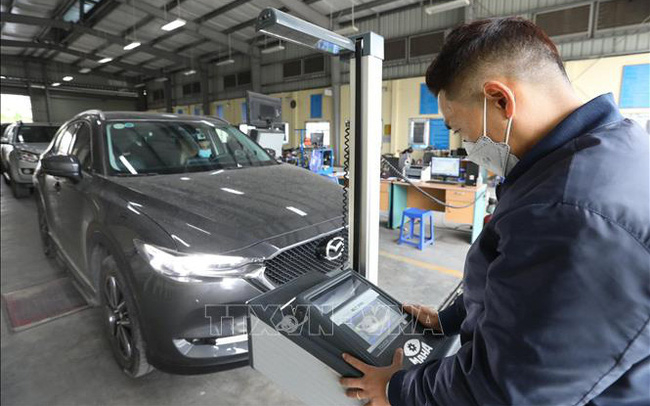 Kiểm định viên Trung tâm đăng kiểm xe cơ giới 2917D tại quận Long Biên đo hệ thống chiếu sáng của xe. Ảnh: Hoàng Hiếu/TTXVN