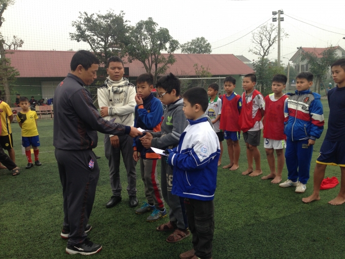 Thầy Hồ Sỹ Ph&uacute;c, đại diện cho phụ huynh v&agrave; c&aacute;c nh&agrave; hảo t&acirc;m trao qu&agrave; cho c&aacute;c em ngh&egrave;o nhưng đam m&ecirc; với tr&aacute;i b&oacute;ng.