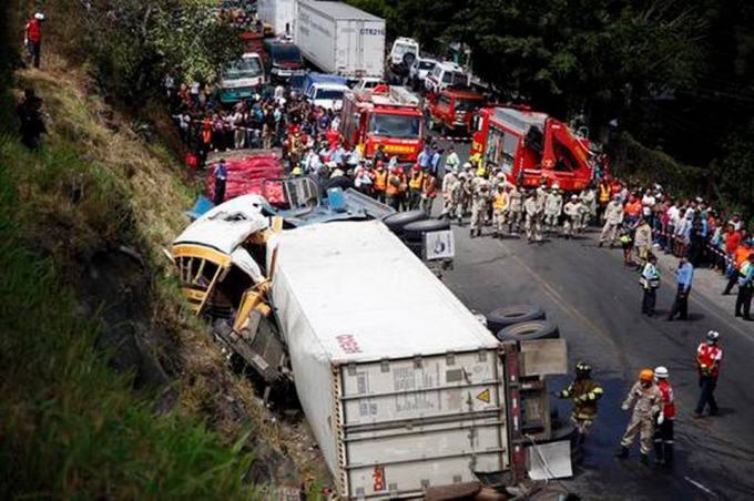 Tại hiện trường vụ tai nạn chiếc xe tải nằm &uacute;p tr&ecirc;n đường trong khi chiếc xe bus bị bẹp r&uacute;m sau c&uacute; va chạm mạnh. (Ảnh: AP)