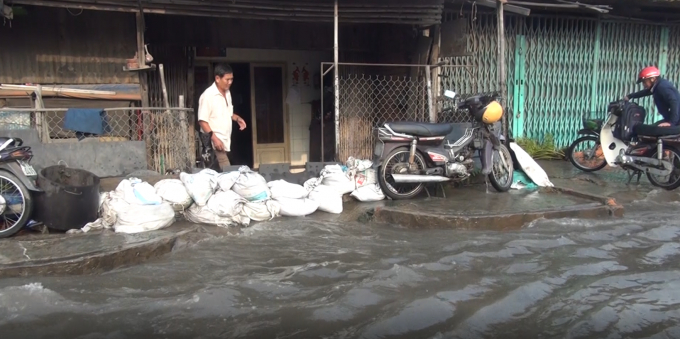 Người d&acirc;n d&ugrave;ng bao chắn ngăn kh&ocirc;ng cho nước v&agrave;o nh&agrave;