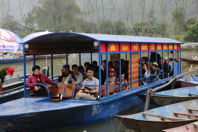 Du kh&aacute;ch ngồi tr&ecirc;n thuyền tham quan cảnh đẹp của khai hội Ch&ugrave;a Hương.