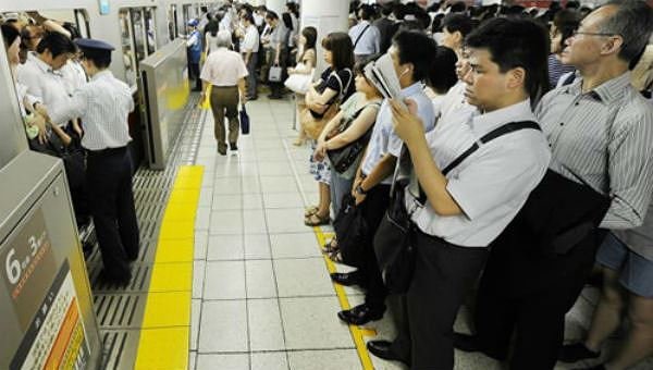 Người d&acirc;n đứng xếp h&agrave;ng tại một ga t&agrave;u điện ngầm ở Tokyo, Nhật Bản.
