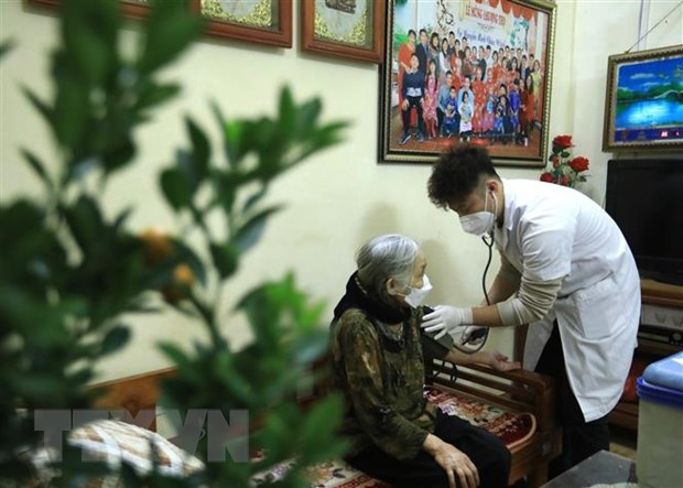 Bà Bùi Thị Nhì (sinh năm 1938) được kiểm tra sức khỏe trước khi tiêm vaccine. (Ảnh: Hoàng Hiếu/TTXVN)