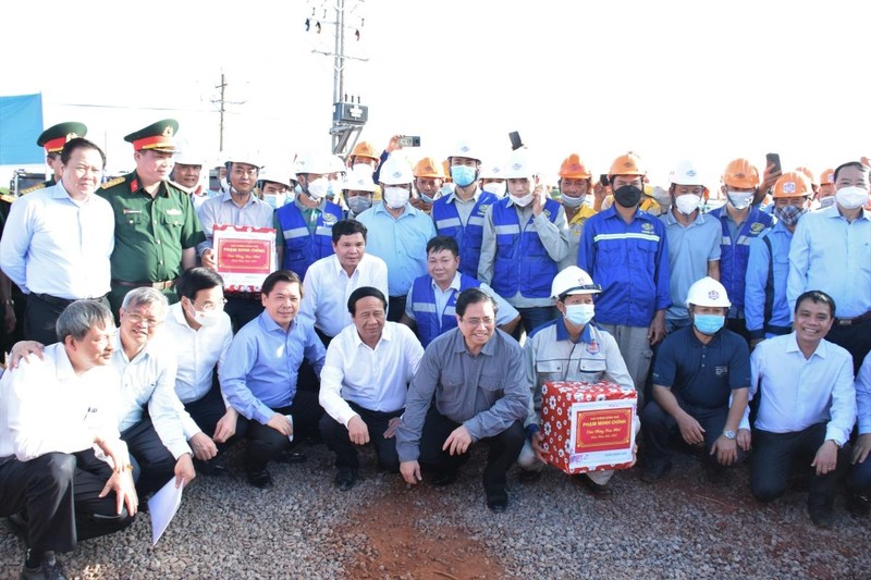 Thủ tướng Chính phủ Phạm Minh Chính và đoàn công tác của Chính phủ chụp ảnh cùng với công nhân thi công dự án.