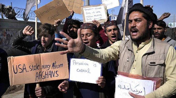 Người biểu tình Afghanistan ở Kabul cầm biểu ngữ và hô khẩu hiệu trong cuộc biểu tình lên án quyết định của Tổng thống Joe Biden về khoản dự trữ của Afghanistan tại Mỹ. Ảnh: AP