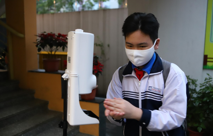 Học sinh thực hiện khử khuẩn trước khi vào lớp khi đi học trực tiếp trở lại. (Ảnh: Nguyễn Nam/Vietnam+).