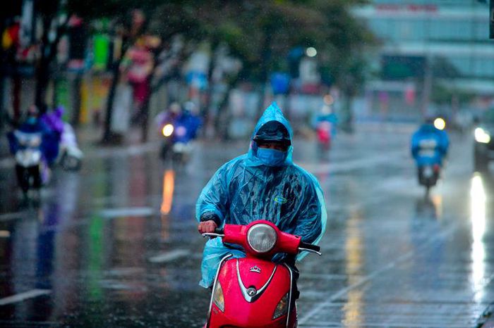 Nhiều người dân Thủ đô co ro trong giá lạnh, có người phải mặc áo mưa khi đi đường.