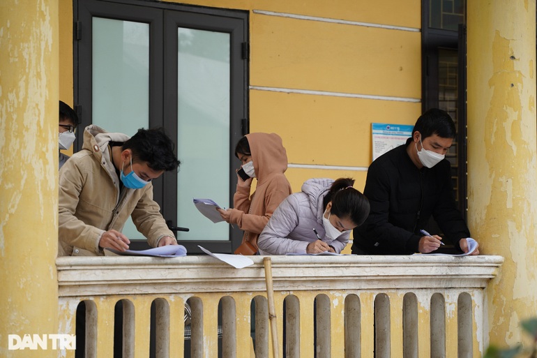 Hình ảnh người dân đứng khai báo y tế dọc hành lang của nhà văn hóa phường Hoàng Liệt.