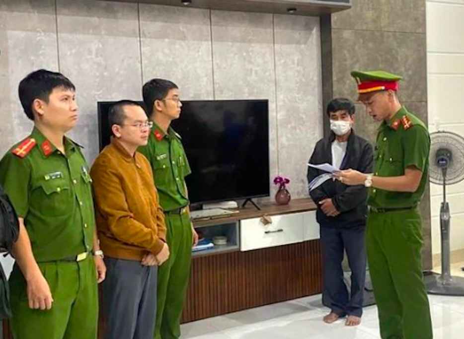 Lực lượng chức năng tống đạt quyết định bắt tạm giam Hoàng Quang Huy (thứ 2 từ trái sang). )Ảnh Công an cung cấp).