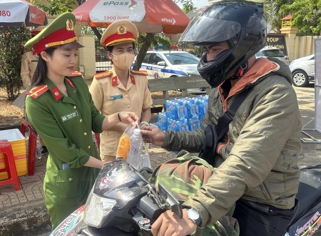 Công an hỗ trợ người dân di chuyển trên xe gắn máy để về quê đón Tết. (Ảnh: TTXVN phát)