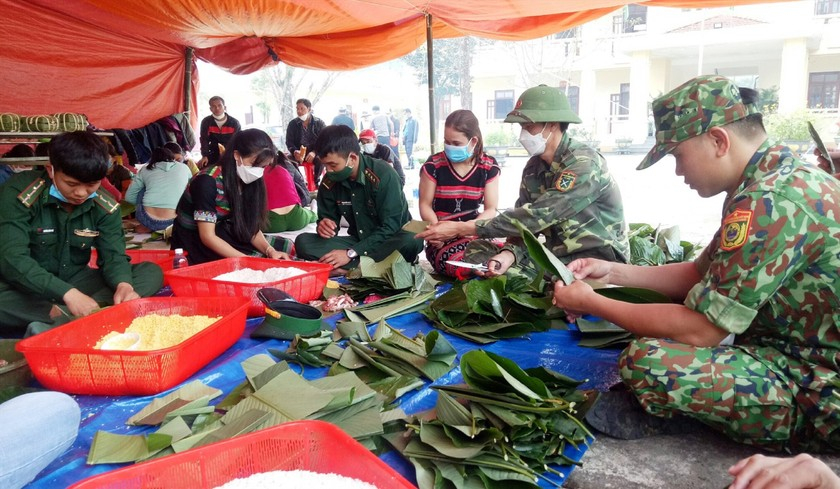 Các chiến sĩ bộ đội biên phòng cùng dân bản gói bánh chưng tặng những người khó khăn đón Tết.