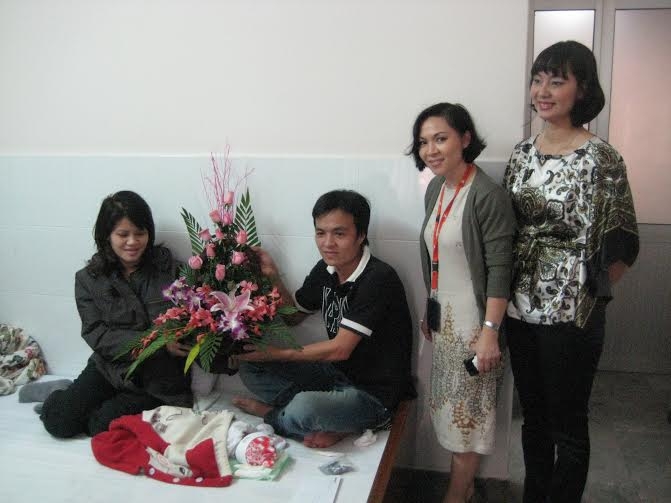 Đại diện Jetstar Pacific thăm v&agrave; tặng hoa cho chị Nguyễn Thị Lập sinh b&eacute; trai tr&ecirc;n m&aacute;y bay năm 2011.