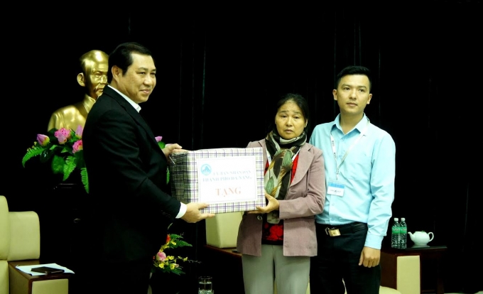 Chủ tịch Huỳnh Đức Thơ trao bảng trưng căn hộ cho b&agrave; Nguyễn Thị Tần v&agrave; con trai.