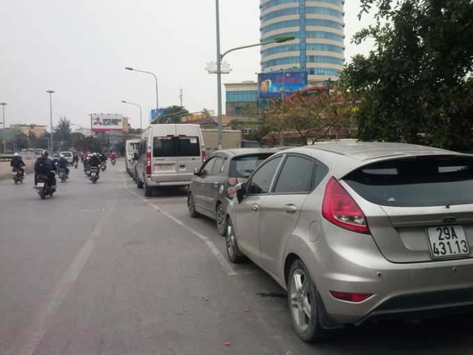 Hàng dài xe ô tô đỗ lấn chiếm hết cả một phần đường dành cho các phương tiện lưu thông trên đường Xã Đàn hướng ra đường Giải Phóng