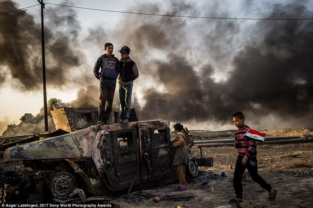 Những cậu b&eacute; chơi trong một khu đất vẫn c&ograve;n dấu t&iacute;ch xung đột ở th&agrave;nh phố Qayyarah, Iraq.