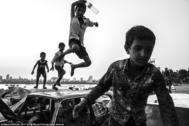 Ảnh chụp ở vịnh Mahim, Mumbai, Ấn Độ. Một nh&oacute;m trẻ chơi trong b&atilde;i chứa xe phế thải.
