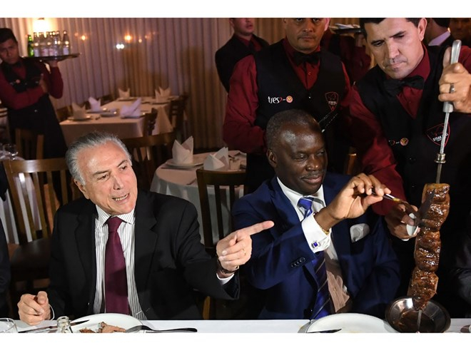Tổng thống Temer (tr&aacute;i) v&agrave; Đại sứ Angola tại Brazil Nelson Manuel Cosme thưởng thức m&oacute;n thịt nướng