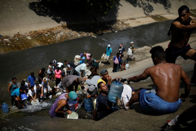 Người d&acirc;n Venezuela buộc phải lấy nước từ đường ống tho&aacute;t nước để đảm bảo sinh hoạt trong những ng&agrave;y thiếu điện. (Ảnh: Reuters)
