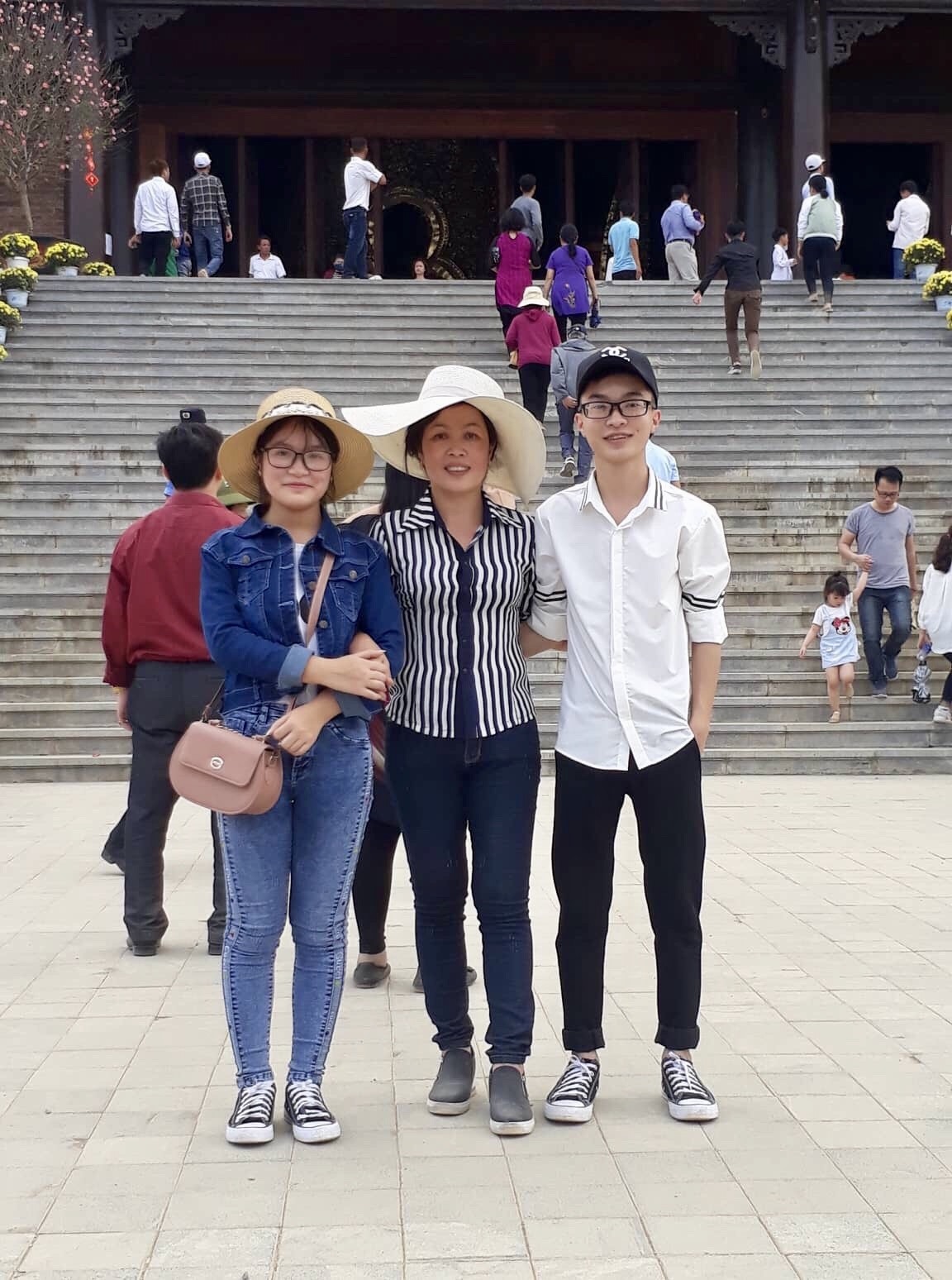 Đinh Việt Thành bên mẹ và em gái. Ảnh: NVCC