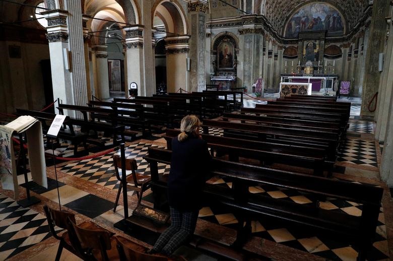 Một người phụ nữ cầu nguyện bên trong nhà thờ Santa Maria Presso San Satiro trống rỗng ở Milan, sau khi các giám mục người Ý ra lệnh không được tổ chức thánh lễ trong tuần tại các nhà thờ ở các khu vực phía bắc của đất nước bị ảnh hưởng bởi sự bùng phát của coronavirus, ngày 5 tháng 3